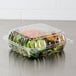 A Dart ClearSeal plastic container with salad and vegetables inside.