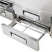 A stainless steel Avantco refrigerator pan divider bar on a table in a professional kitchen.