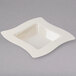 A white square plastic bowl with a wavy edge.