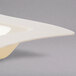 A Fineline Wavetrends bone/ivory plastic bowl with a curved edge.