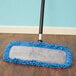 A Lavex blue microfiber mop kit on a wood floor.