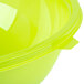 A close up of a green Fineline PET plastic bowl with a yellow and green background.