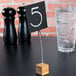 A black square table number card on a wooden stand.