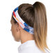 A woman wearing a Headsweats Colorado Ultra Band headband with a colorful design.