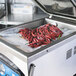 A machine with ARY Vacmaster re-therm vacuum packaging bags containing red peppers.