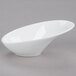 An Arcoroc Lucido porcelain bowl with a curved shape on a gray surface.
