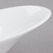 A close up of an Arcoroc Lucido porcelain bowl with a curved edge.