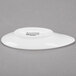 An Arcoroc white porcelain dish with a small hole in the middle and black text.