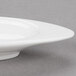 An Arcoroc porcelain dish with a small rim on it.