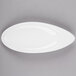 An Arcoroc white oval porcelain dish on a gray surface.