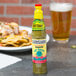 A case of Louisiana Jalapeno Hot Sauce on a table with a plate of food.