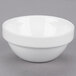 An Arcoroc porcelain bowl with a white rim on a gray surface.