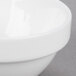 An Arcoroc white porcelain stackable bowl with a white rim.