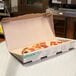 A GreenBox pizza box with two slices of pizza in it.