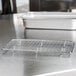 A stainless steel metal rack with many metal bars on a counter.