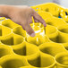 A hand reaching out to a yellow Carlisle glass rack extender with glasses inside.