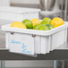 A white Metro Divider Tote Box with lemons and limes in it.