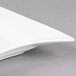 A close-up of a CAC rectangular bone white porcelain platter with curved edges.