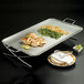 A stainless steel American Metalcraft X-leg griddle stand with food on it.