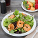 A Bare by Solo medium weight paper plate with salad, shrimp, and fruit.