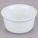 A white Cambro porcelain bowl on a gray surface.