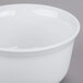 A white Cambro porcelain bowl on a gray surface.