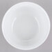 A white Cambro porcelain bowl with a white rim on a gray background.