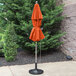 A Grosfillex orange fiberglass umbrella on a patio.