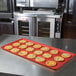 A red MFG Tray supreme display tray of cookies on a counter.