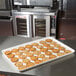 A white MFG Tray Supreme Display Tray with cookies and multicolored sprinkles on a counter.