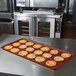 A burgundy MFG fiberglass display tray with cookies on a counter.