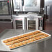 A row of cookies on a MFG Tray Supreme Display Tray on a counter.