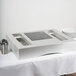 A white rectangular Tablecraft countertop induction station with a black square induction cooker on it.