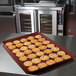 A burgundy MFG Fiberglass Display Tray with cookies on a counter.