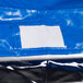 A blue tarp with a white rectangle that reads "Heavy Duty Bun Pan Rack Freezer Cover"