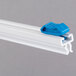 A blue plastic clip on a white piece of plastic with a blue connector.