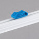 A blue plastic clip on a white rail with the Edlund Film Dispenser Blade.