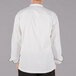 The back of a Mercer Culinary white chef jacket with black piping.