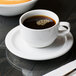 A cup of coffee on a Libbey Reflections Aluma White porcelain saucer.