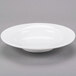 A Libbey white porcelain deep soup bowl on a gray surface.