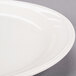 A close-up of a Libbey ivory porcelain oval medium rim plate.