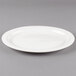 A Libbey ivory porcelain platter with a rim on a gray background.