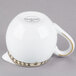 A white Syracuse China creamer with a gold rim and a handle.