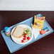 A Cambro robin egg blue dietary tray with a sandwich, chips, and a drink on it.