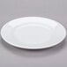 A Libbey Reflections white porcelain plate with a rim on a gray surface.