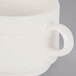 A close-up of a Libbey ivory porcelain mug with a white handle.