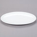 A white oval Libbey Aluma White porcelain platter on a gray surface.