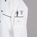 A Mercer Culinary white chef jacket with black piping and a pocket.