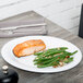 A Diamond White oval melamine platter with salmon and green beans on it.