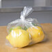 A close-up of a LK Packaging plastic bag with lemons inside.